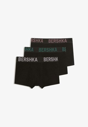 Három fekete boxeralsó egymáson, mindegyiken eltérő színű "BERSHKA" logó a derékpánton: lila, türkiz és szürke.