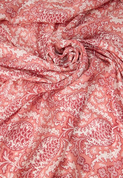 Μαλακό ύφασμα με περίτεχνο ροζ και λευκό σχέδιο paisley, ελαφρώς μαζεμένο σε σπειροειδή στροβιλισμό.