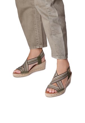 Wedge sandals with green and beige striped fabric straps, open toe, and jute-wrapped wedge heel, featuring a smooth texture.