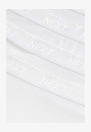 Tissu blanc avec des bandes élastiques brodées visibles affichant le mot "NEXT" en blanc, présentant un bord en scallop et une texture douce.