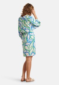 Kurzärmeliges Kleid aus weißem Stoff mit blauen und grünen Blattmustern, tailliert mit einem Gürtel, knielang und in lockerer Passform.