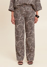 Wijde broek met een zwart en crèmekleurig golfpatroon, gemaakt van soepel stof, voorzien van zijzakken en een aansluitende tailleband.