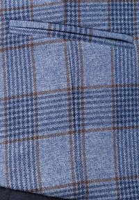 Niebieska tkanina w kratkę z teksturowanymi splotami. Wzór zawiera ciemnoniebieskie i brązowe linie, z ukośnym detalem kieszeni.