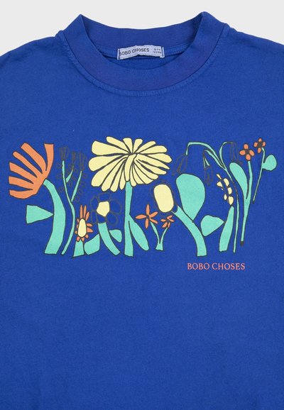 Blaues Kindershirt mit bunten abstrakten Blütenmustern in Orange, Gelb und Türkis sowie dem Schriftzug "BOBO CHOSES" unter dem Design.
