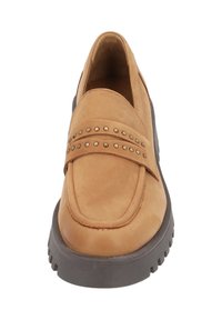 Tan suede slip-on shoe with a padded collar, featuring metal studs on the strap and a chunky black sole. Smooth texture, rounded toe design.