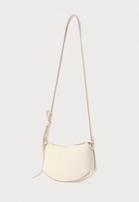 Τσάντα χιαστί από κρέμ δέρμα με καμπυλωτό σχήμα, κλείσιμο με φερμουάρ και λεπτό ρυθμιζόμενο λουράκι. υφή με λεία λεπτομέρεια.