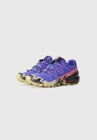 Salomon trail čizme za trčanje, gornji dio od ljubičastog tekstila, crno-žuta potplata, prepoznatljiv uzorak otpora, elastične vezice i vidljivi logo.