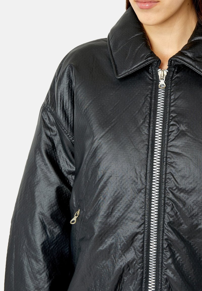 Schwarze gesteppte Jacke mit glänzendem Finish, großem Kragen und Frontreißverschluss. Verfügt über eine seitliche Tasche mit Reißverschluss und elastischen Bündchen.