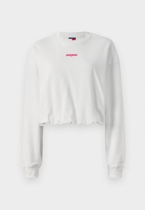 White cropped sweatshirt made of soft fabric, featuring long sleeves and a red logo "tommy jeans" centered on the chest.
