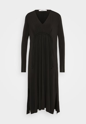 Black long-sleeve dress with a V-neck, gathered waist, flowing fabric, side slits, and drawstring detailing. Made from lightweight material.