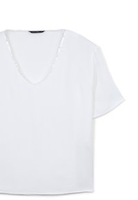 Blusa bianca con scollo a V, maniche corte e un tessuto leggero e liscio. Presenta una leggera lucentezza e un orlo dritto.