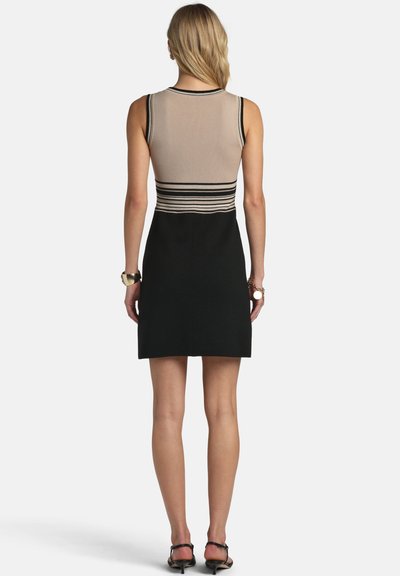 Kötött ruha, bézs színű bordázott felsőrésszel fekete vízszintes csíkokkal, amely egy testhez simuló fekete szoknyába megy át. Sima textúra, ujjatlan kialakítás.