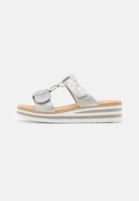 Zilveren metallic sandalen met een brede band en ronde accenten, voorzien van een kurken voetbed en een gelaagde witte zool met grijze strepen.