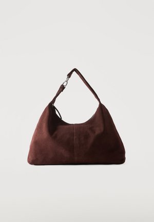 Sac bandoulière en daim marron doux avec une seule lanière et des accessoires métalliques argentés sur un fond clair uni.