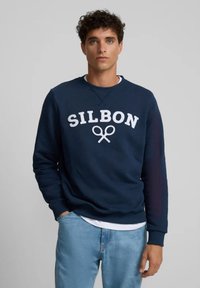 Sudadera de color azul marino hecha de algodón, con letras en blanco "SILBON" y un gráfico de tijeras, cuello redondo y puños acanalados.