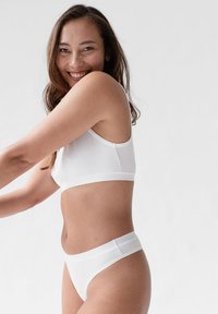 Weißer Baumwoll-Bralette und passende Hipster-Unterwäsche, mit glatten Kanten und engem Sitz. Einfaches Design ohne sichtbare Muster oder Hardware.