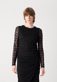 Schwarzes Langarmoberteil mit transparenten Mesh-Ärmeln, die ein sich wiederholendes DKNY-Logo-Muster aufweisen, texturiertem Körper und Rundhalsausschnitt.