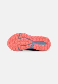 Semelle de chaussure avec un motif en losanges texturé en orange et bleu, arborant un logo de marque bien en vue et un design symétrique et léger.