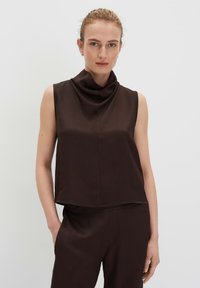 Top marrone senza maniche con scollatura drappeggiata. Realizzato in un tessuto liscio, presenta una vestibilità leggermente larga e cuciture minime.