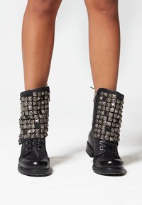 Čierne členkové topánky so striebornými ozdobami a pyramídovými akcentmi, šnurovacie vpredu a so zipsom na boku.