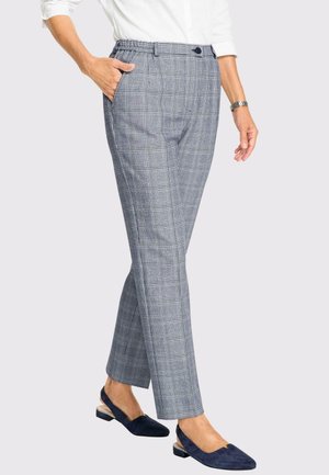 Pantalons à carreaux dans des teintes de gris avec une taille élastique, des poches latérales et une coupe droite, associés à des chaussures bleu marine.