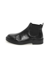 Bota Chelsea de cuero negra con un upper liso, paneles laterales elásticos, tirador y una suela de goma baja para mayor comodidad.