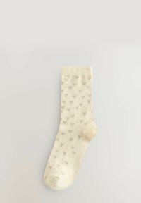 Beige Socken mit einem dezenten Muster aus kleinen grauen Herzen, mit geripptem Bündchen und weichem, strukturiertem Stoff.