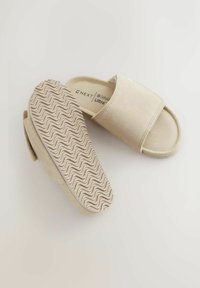 Beige libedad sandaalid pehme suède viimistlusega, laia rihma kujunduse ja lainelise kummist talda mustriga, mis tagab haarde ja mugavuse.