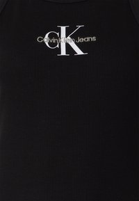 Czarny prążkowany top na ramiączkach z białym logo "CK" oraz napisem "Calvin Klein Jeans". Gładka tekstura, dopasowany krój i kontrastowy dekolt.