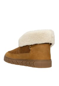 Braune Wildleder-Stiefelette mit einem weichen weißen Kunstfellbund, strukturiertem Sohlenprofil und einer seitlichen Schlaufe für einfaches Anziehen.