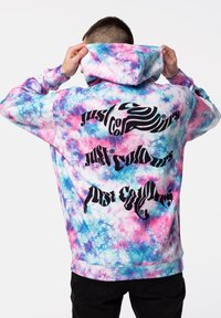 Felpa con cappuccio in un motivo tie-dye con tonalità di rosa, blu e bianco. Presenta un grande testo nero sul retro, che indica il nome del marchio.