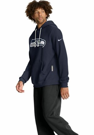 Sweat à capuche bleu marine avec un logo Seattle Seahawks, capuche avec cordon de serrage, poche kangourou et poignets côtelés. Fabriqué en matière douce pour plus de confort.