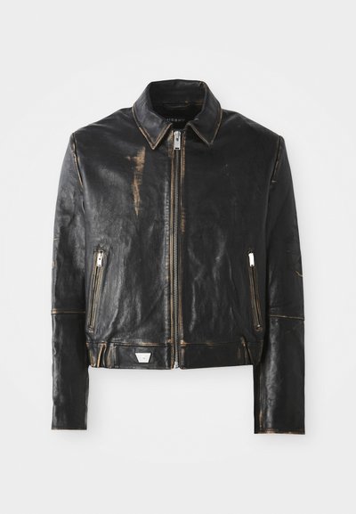 Melnā ādas jaka ar klasisku apkakli, priekšējo rāvējslēdzēju, divām rāvējslēdzēja kabatām un izbalējušu apdari, kas izceļ tekstūru un dizainu.