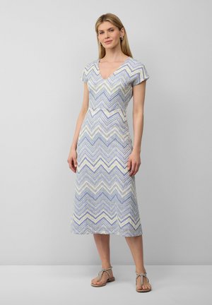 Korte mouwen, V-hals jurk in een zigzagpatroon van blauw, paars en geel. Midden kuitlengte met een getailleerde taille en een vloeiende onderkant.