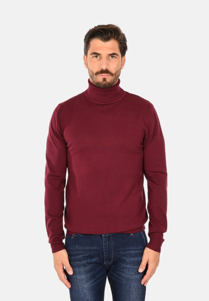 Maglione a collo alto color bordeaux realizzato in un tessuto morbido, design aderente e polsini a costine. Abbinato a jeans in denim scuro.