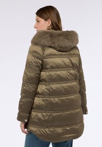 Oliwkowa zielona kurtka puchowa z kapturem wyłożonym sztucznym futrem, pionowym przeszyciem, kieszeniami na zamek i lekko dopasowanym krojem.