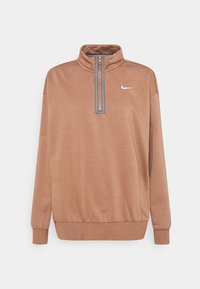 Brun Nike-tröja med hög krage, halvklar front, ribbade ärmslut och midja; har en liten vit logotyp på vänster bröst.