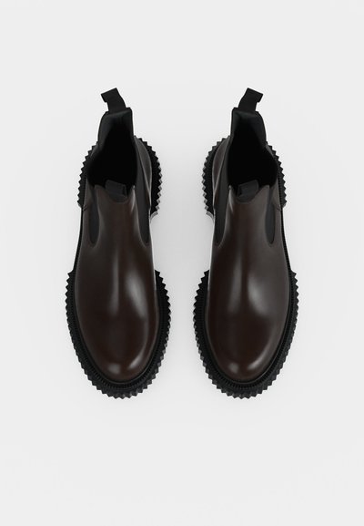 Paire de bottines Chelsea en cuir marron foncé brillant avec des panneaux latéraux élastiques noirs et des semelles noires épaisses rainurées vues de dessus.