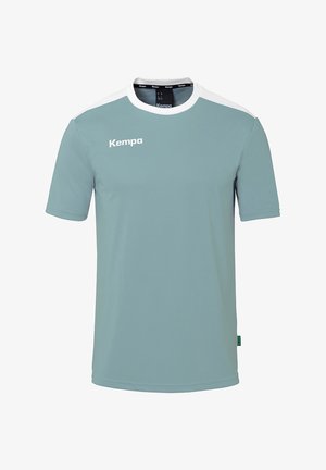 Helderblauwe T-shirt met korte mouwen, witte schouderaccenten en het "Kempa" logo aan de voorkant. Gemaakt van een gladde, synthetische stof.