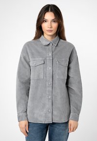 Grijze corduroy overhemdjack met een knoopsluiting aan de voorkant, twee borstzakken en een kraag. Met een textuurrijke stof en een ontspannen pasvorm.