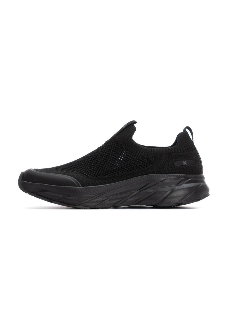 Las zapatillas negras sin cordones cuentan con una parte superior de malla texturizada, suela de goma y un diseño suave y contorneado con una pestaña trasera para ponerlas fácilmente.