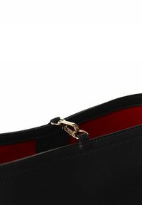 Borsa in pelle nera con chiusura in tonalità oro e interno rosso. Presenta un design elegante e una texture liscia senza motivi visibili.