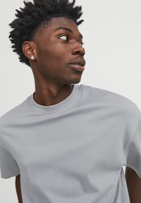 Grey, short-sleeve crew neck t-shirt made of cotton blend fabric, smooth texture, and minimal design with no visible patterns or accents.