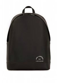 Musta reppu, joka on valmistettu sileästä materiaalista ja pyöreämuotoinen. Siinä on vetoketjullinen suljin ja valkoinen logodetalji alareunassa. Yksinkertainen ja moderni muotoilu.