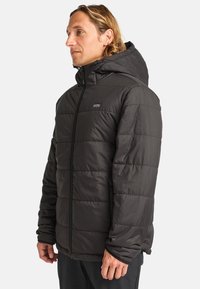 Giacca a vento nera imbottita con cappuccio, caratterizzata da un design trapuntato, zip frontale e un piccolo logo sul petto. Materiale liscio e resistente all'acqua.