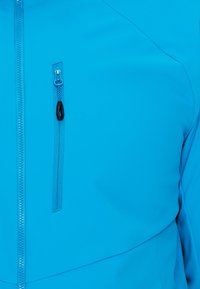 Blaues, mit Reißverschluss versehenes Jackett mit einem eleganten Design, glatter Textur und einer auffälligen Seitentasche mit kontrastierendem schwarzen Reißverschluss-Zug.