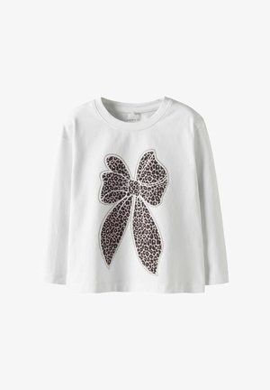 Camicia bianca a maniche lunghe con una grande grafica a forma di fiocco leopardato rosa e nero al centro. Materiale in cotone morbido con scollatura rotonda.