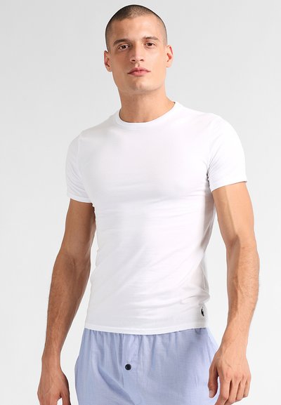 T-shirt en coton blanc avec un col rond, des manches courtes et une coupe slim. Présente un petit logo de la marque en bas à gauche.