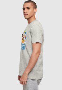 Camiseta de algodón gris con un estampado colorido de personajes en caricatura, de mangas cortas, cuello redondo y un diseño de ajuste relajado.