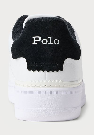 White sneaker with a black suede heel tab featuring "Polo" in white text. Textured rubber sole with zigzag accents. Smooth synthetic upper.